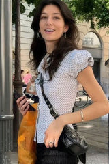 Chemisier à pois avec nœud décoratif et manches bouffantes.