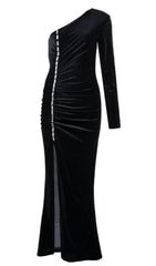 Robe longue noire à une épaule fendue sur fond de velours à motif diamant.
