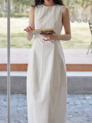 Robe maxi sans manches assortie à un sac à main en paille tressée