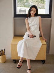 Robe maxi sans manches assortie à un sac à main en paille tressée