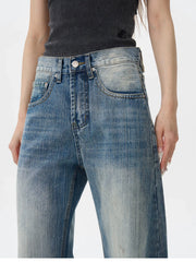 Jean bleu à jambes larges et usé aux genoux.