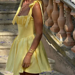 Robe mini plissée jaune à dos nu